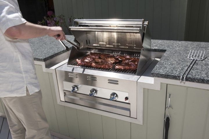 Outdoor traditional brick with bi-level bar island for eating and prep. Stainless grill, covered area in back yard.