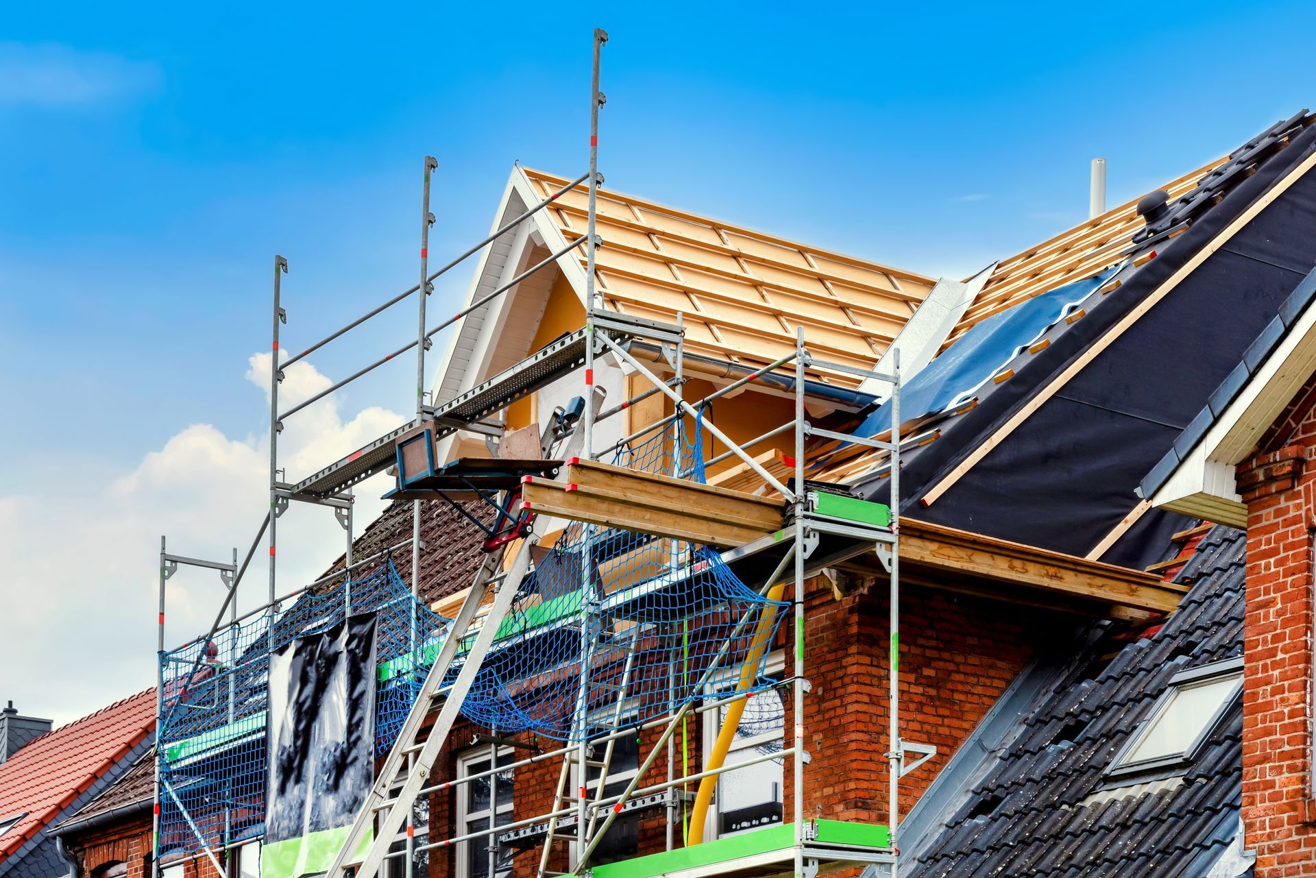 A house is being built with scaffolding on the roof.