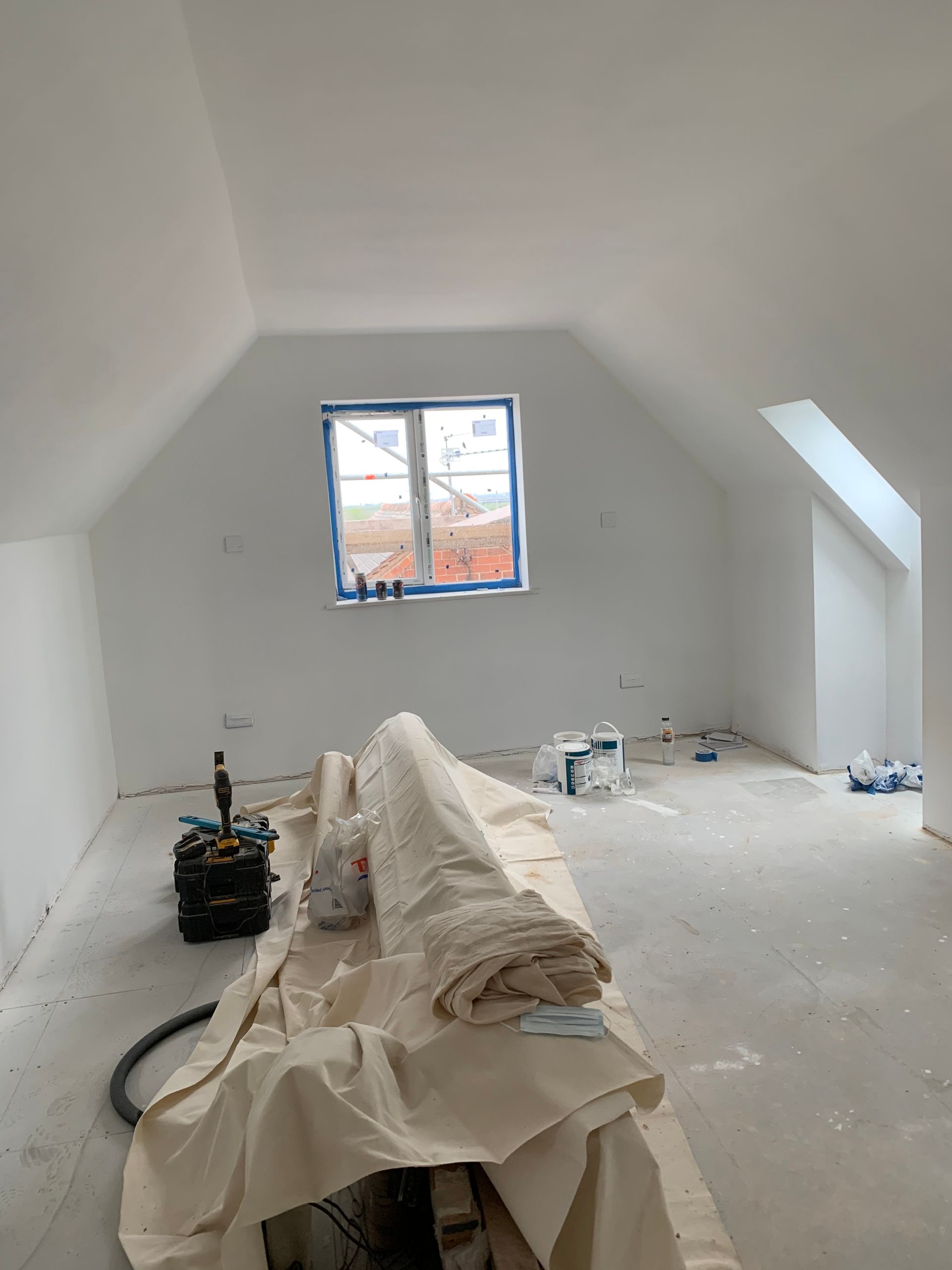 An empty room with a window and a blanket on the floor.