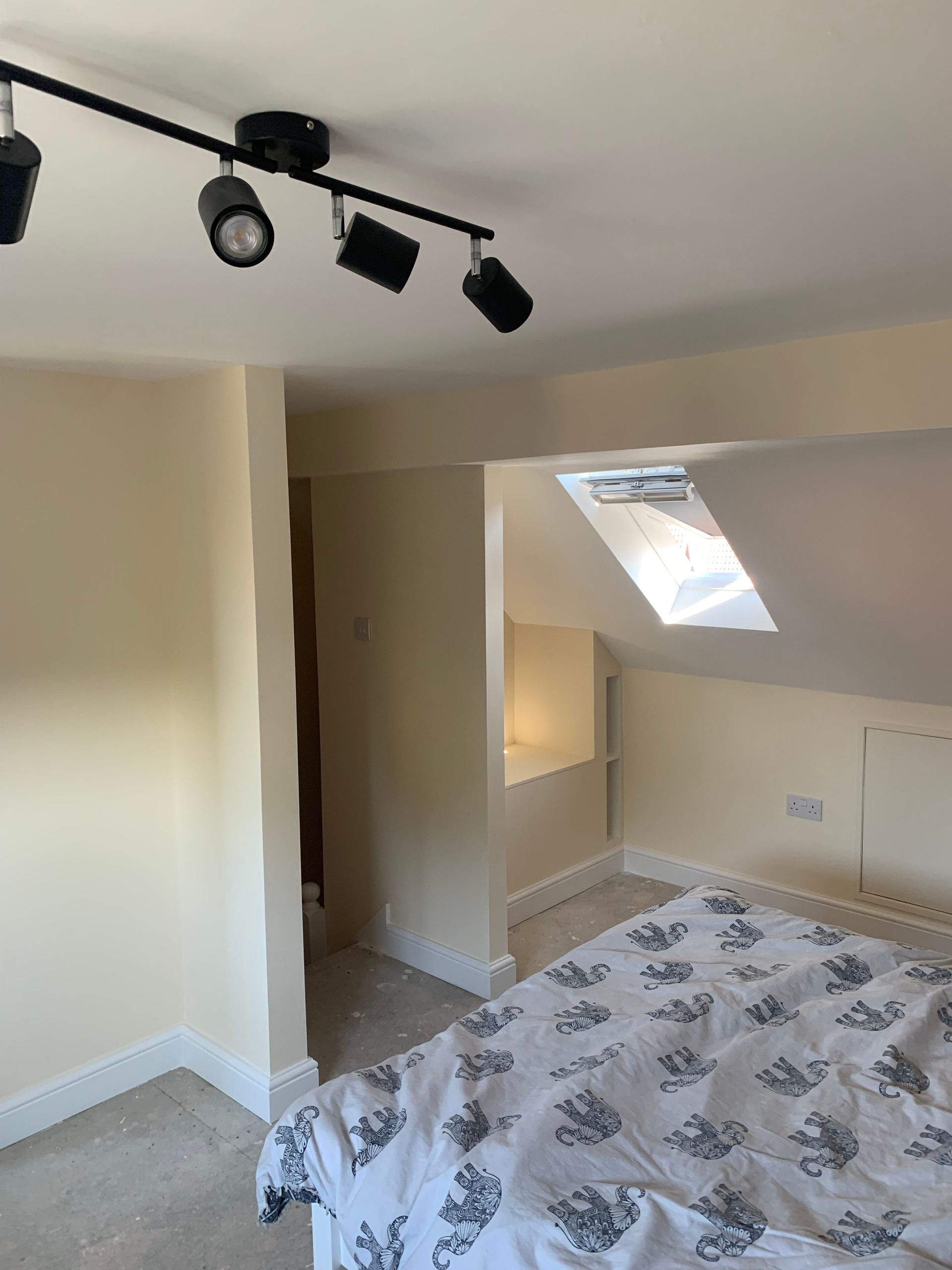 A bedroom with a bed and a ceiling light.