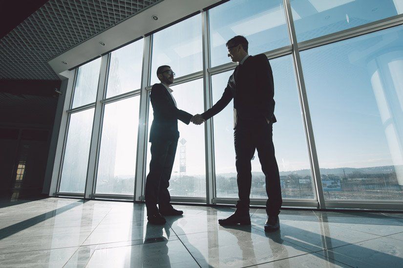 Two Young Businessmen are Shaking Hands — Property Lawyers in Darwin, NT