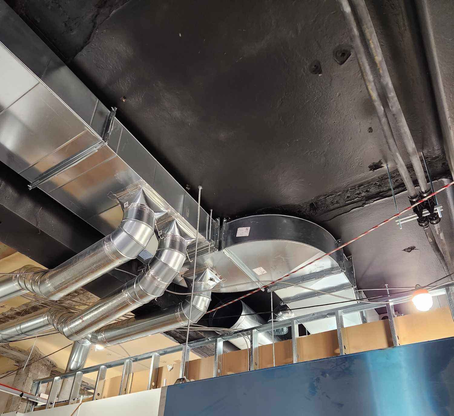 Un plafond avec beaucoup de tuyaux suspendus