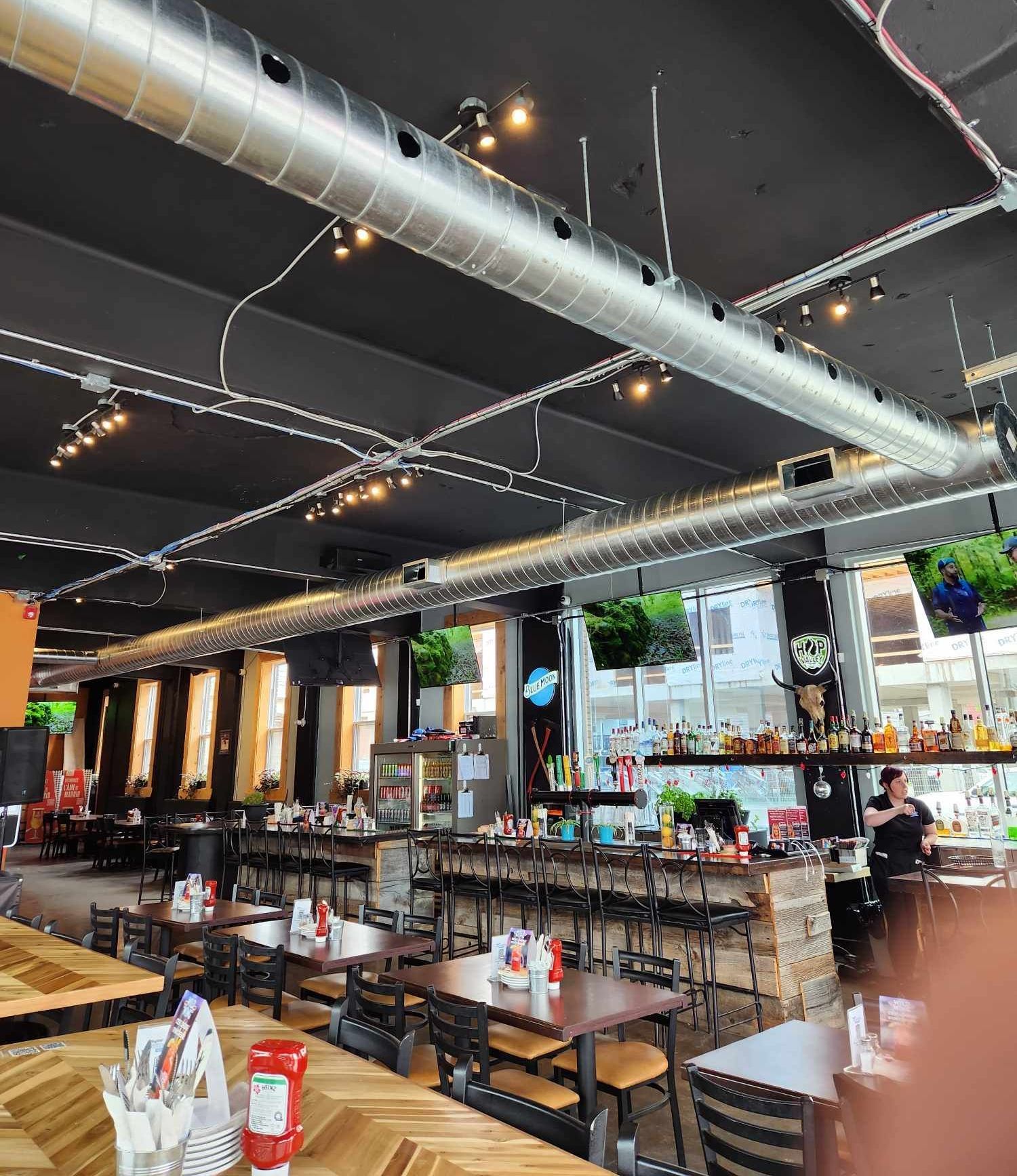 Un restaurant avec tables et chaises et un bar.