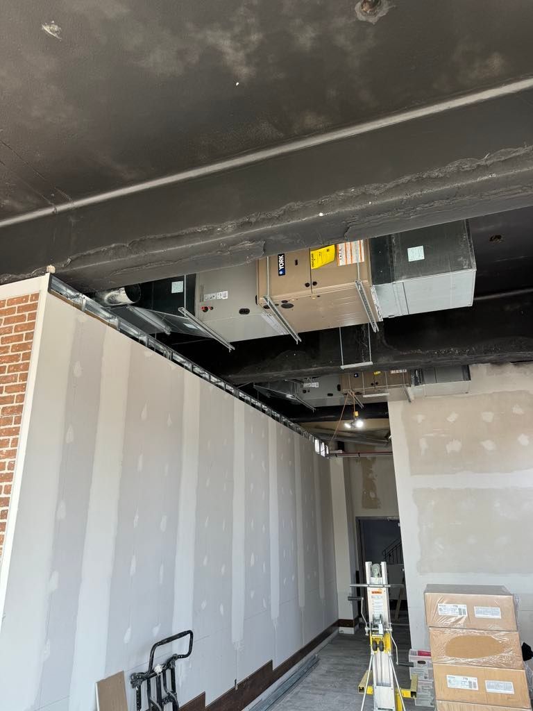 Une pièce en construction avec une échelle et des cartons au sol.