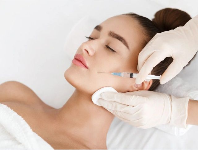 Signature Aesthetics injecting Botox into a client's cheek in Nottingham