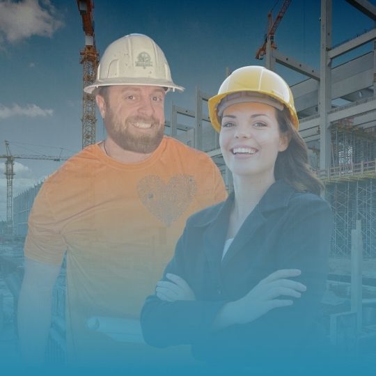 A man and a woman wearing hard hats are posing for a picture