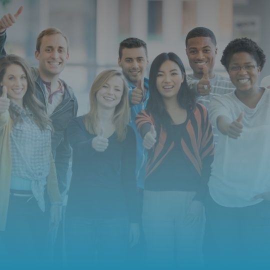 A group of people are posing for a picture and giving a thumbs up.