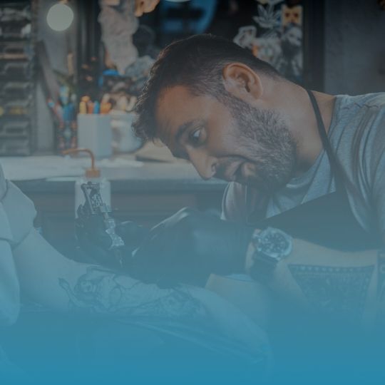 A man is getting a tattoo on his arm.