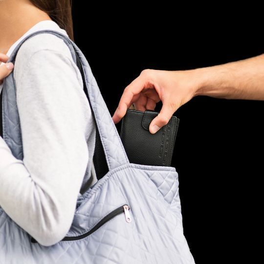 A man is taking a wallet out of a woman 's bag