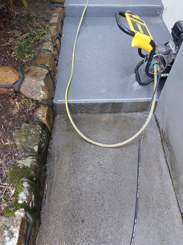 A Yellow Hose Is Attached To A Power Cord On A Sidewalk — Amaze Lawn and Garden Care In Anna Bay, NSW