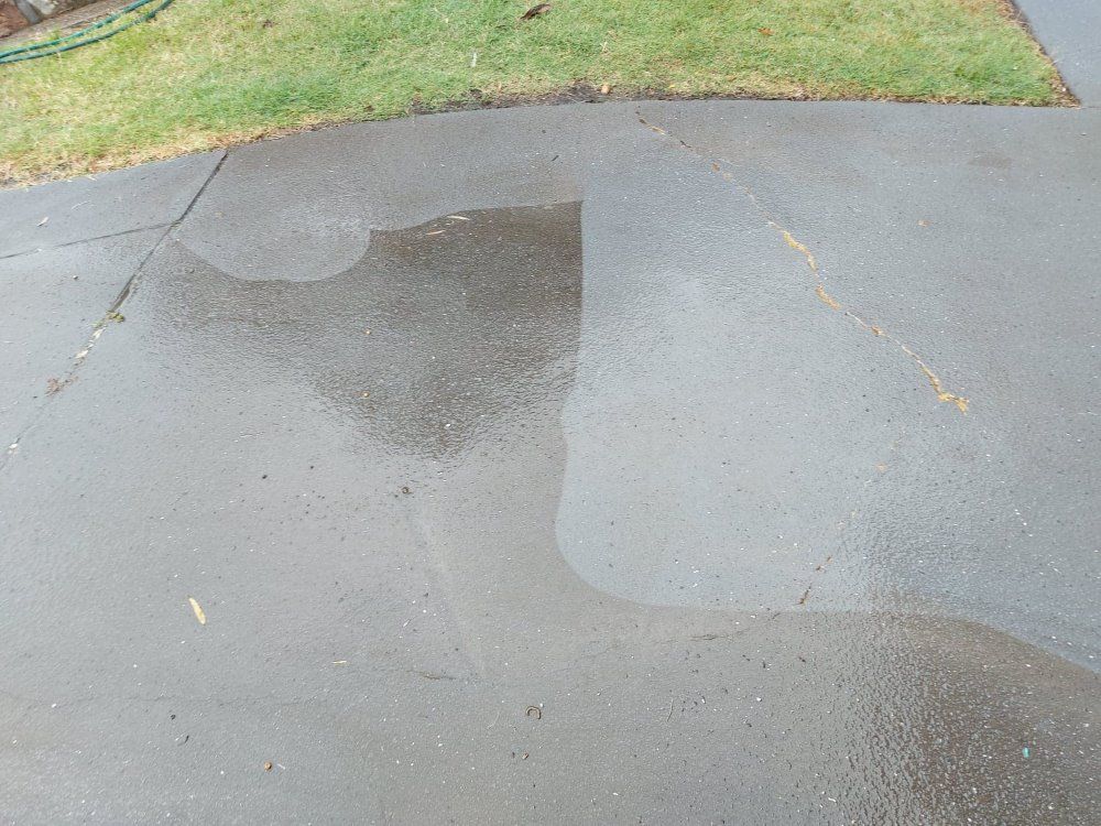 A Driveway Is Being Cleaned Using A Pressure Washer — Amaze Lawn and Garden Care In Nelson Bay, NSW