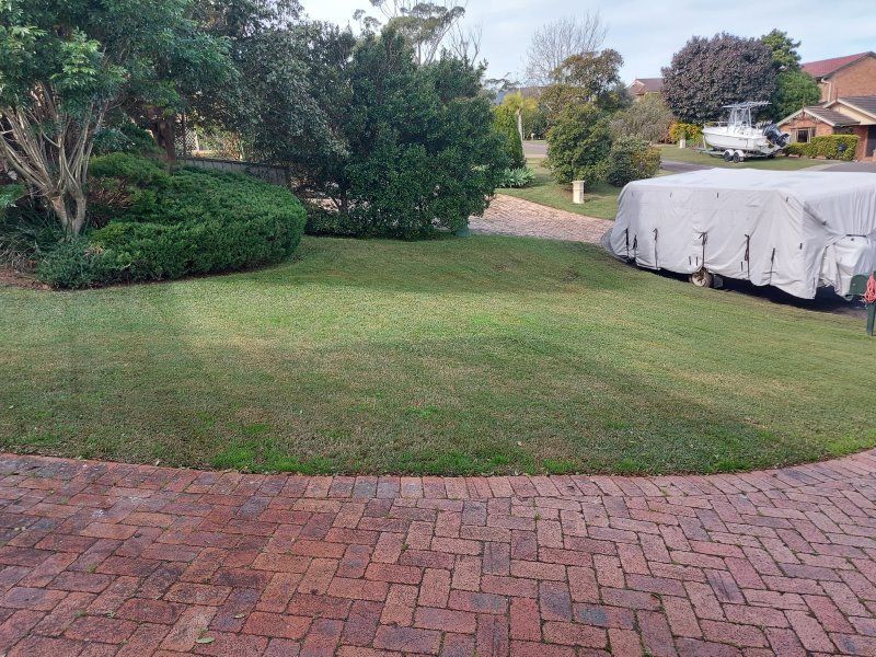 A Brick Driveway Leading To A Lush Green Lawn — Amaze Lawn and Garden Care In Nelson Bay, NSW