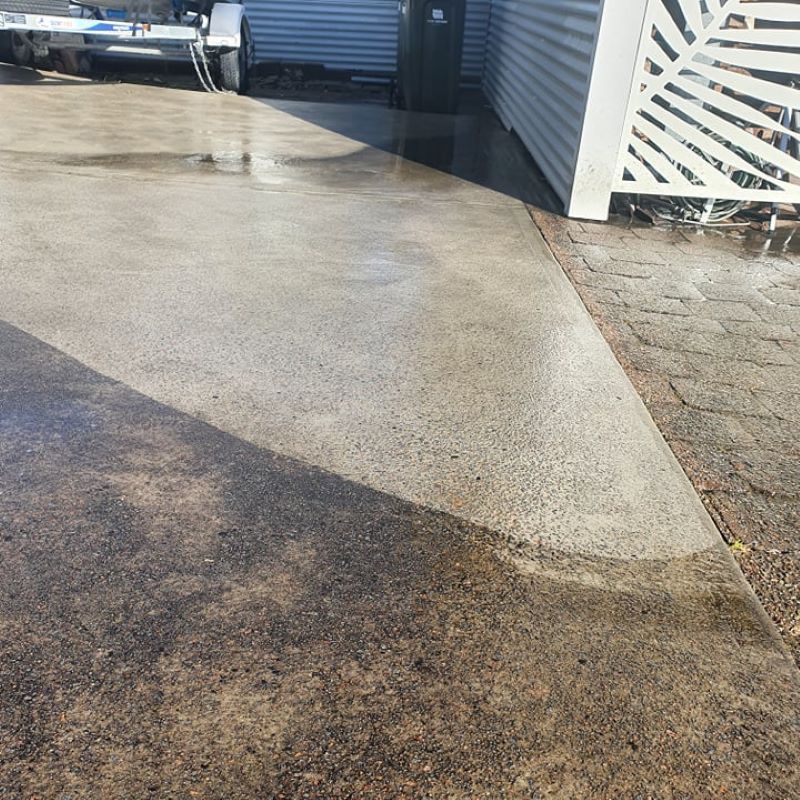A Concrete Driveway With A White Fence In The Background — Amaze Lawn and Garden Care In Nelson Bay, NSW