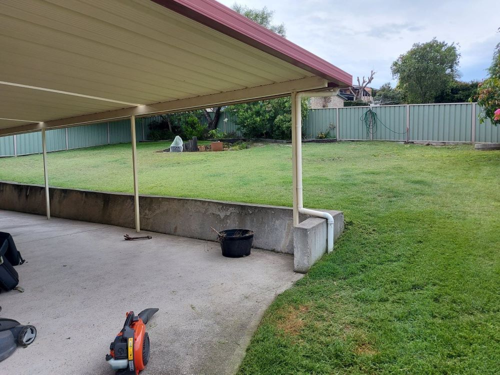 A Lawn Mower Is Sitting Under A Covered Area In A Backyard — Amaze Lawn and Garden Care In Nelson Bay, NSW