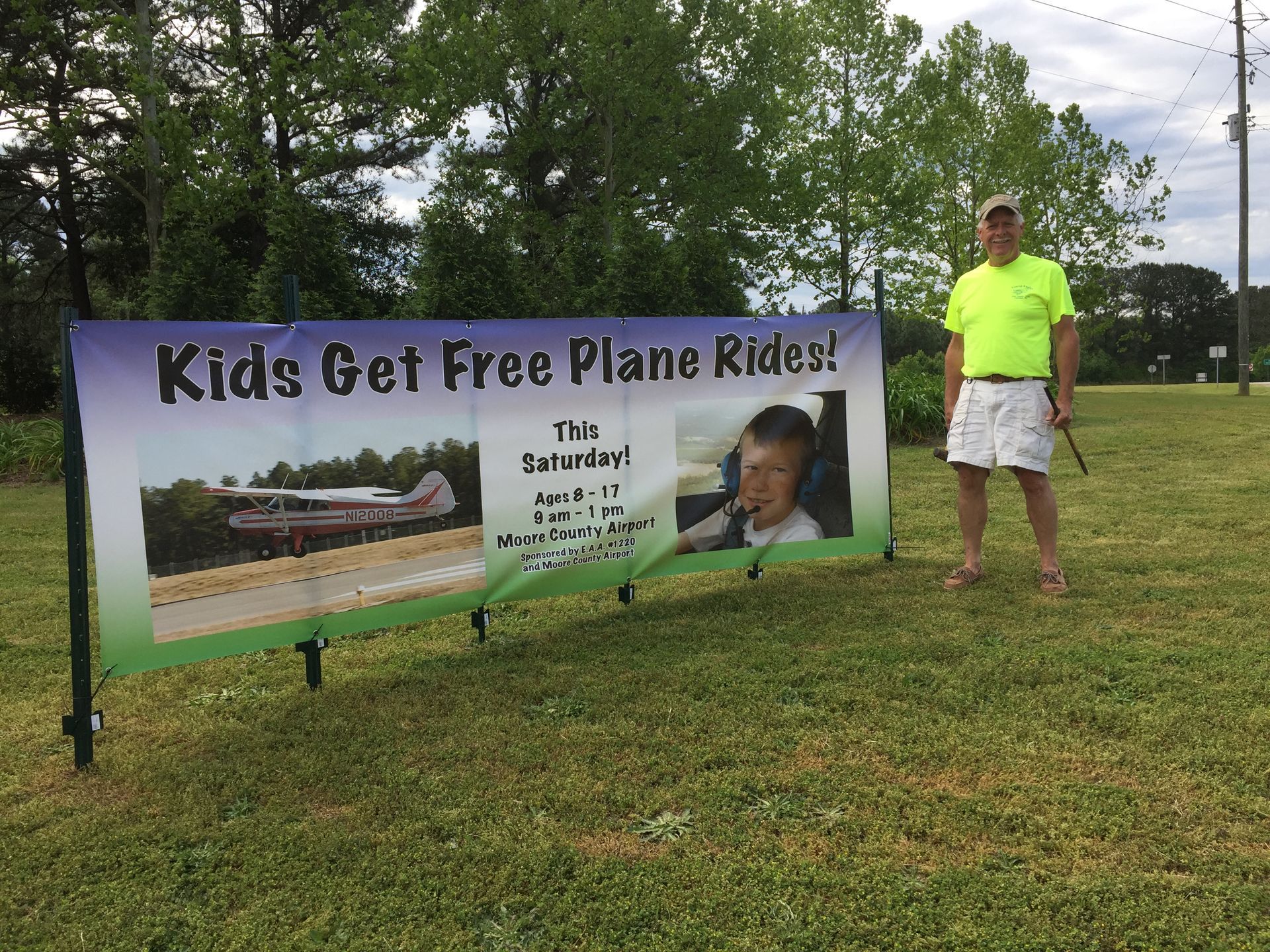 A person stands beside a banner advertising 