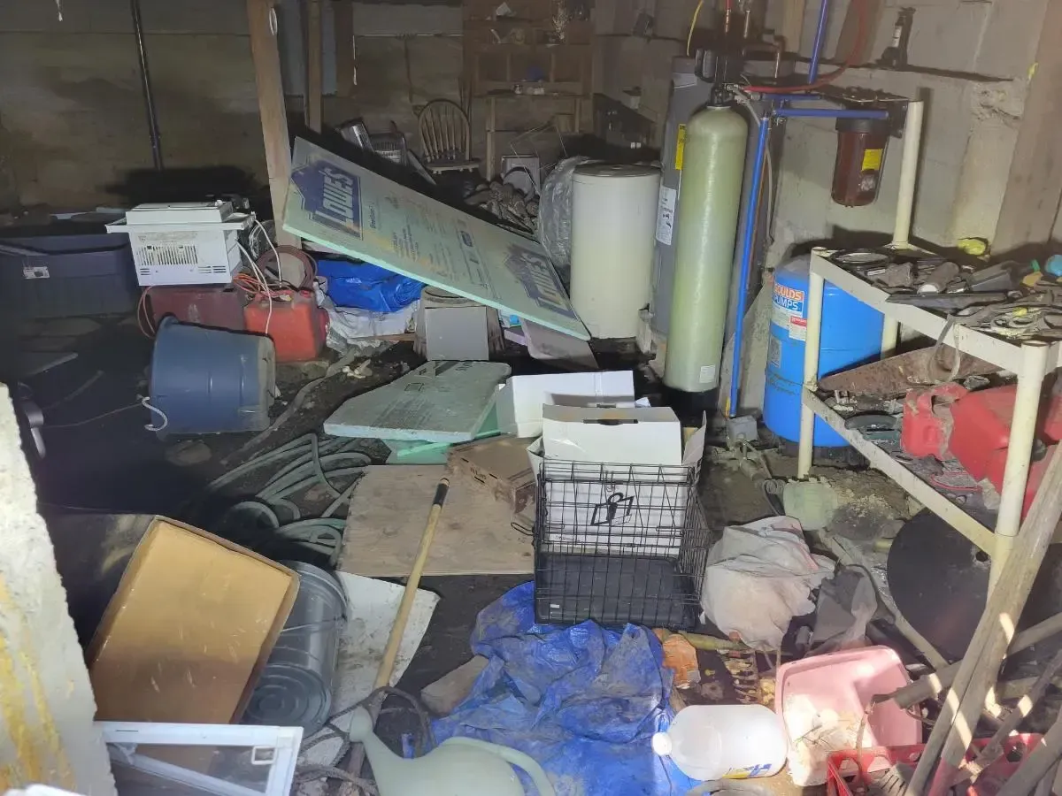 Cluttered basement: storage tanks, debris, and miscellaneous items scattered across the floor.