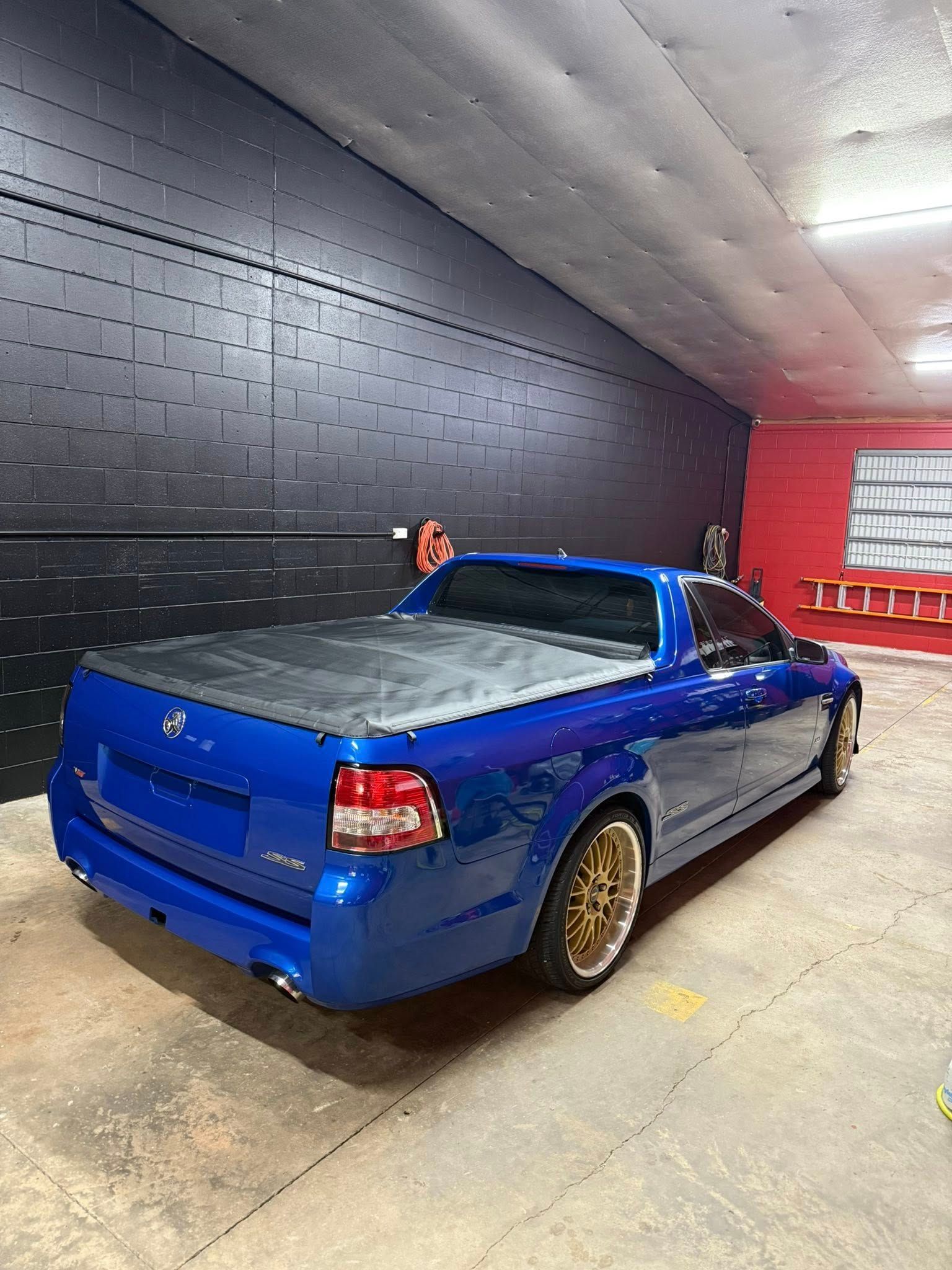 A Bright Blue Utility Vehicle With Gold Wheels Parked Inside a Garage — Mobile Club Cars Cairns in Tully, QLD