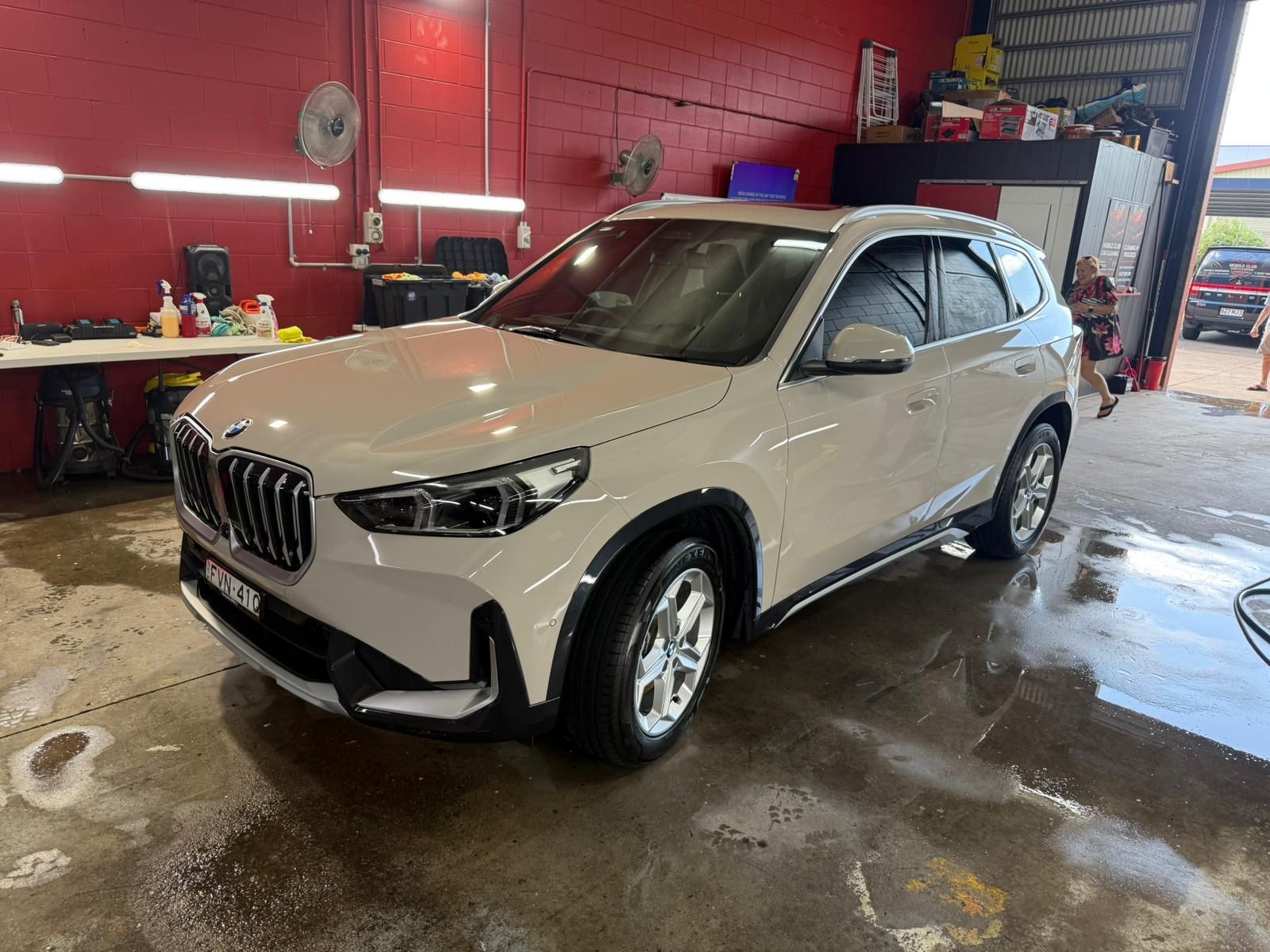 Tan BMW SUV parked inside a car wash bay with a red wall — Mobile Club Cars Cairns in Earlville, QLD