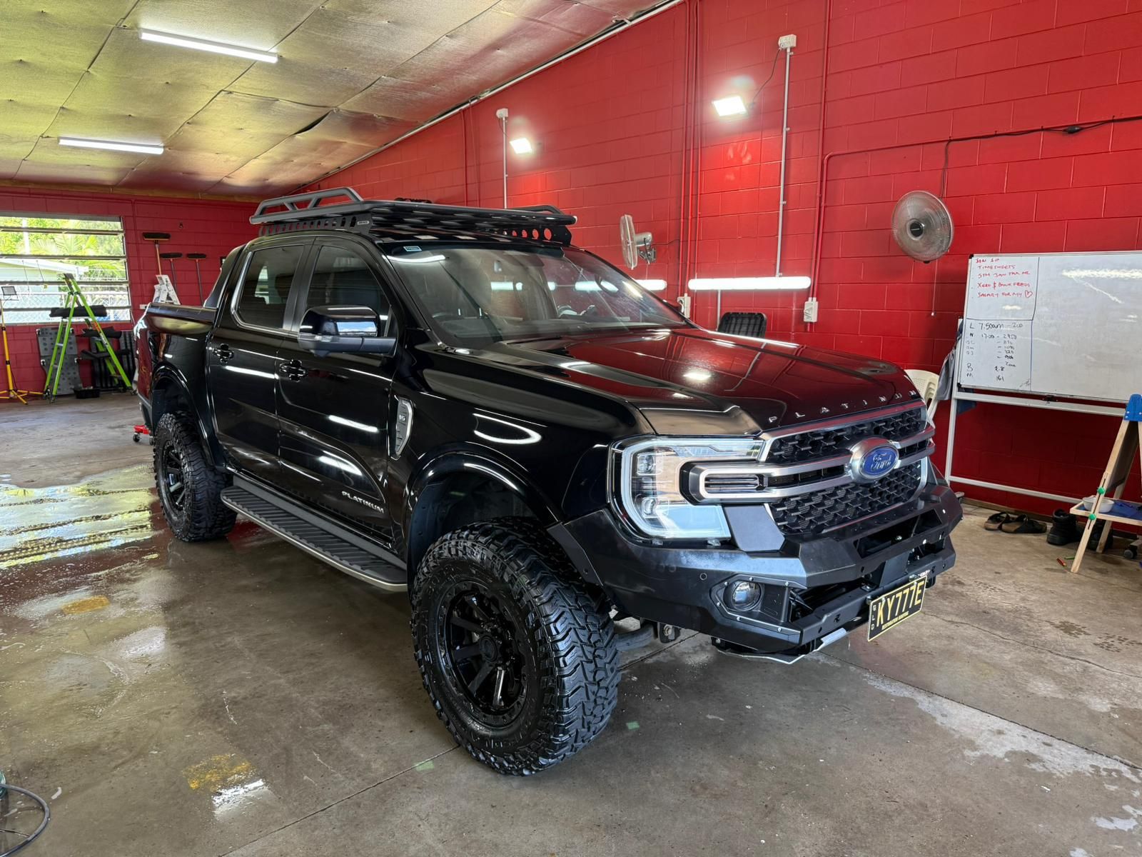 Black Ford pickup truck with roof rack, off-road tires, parked in a garage — Mobile Club Cars Cairns in Earlville, QLD