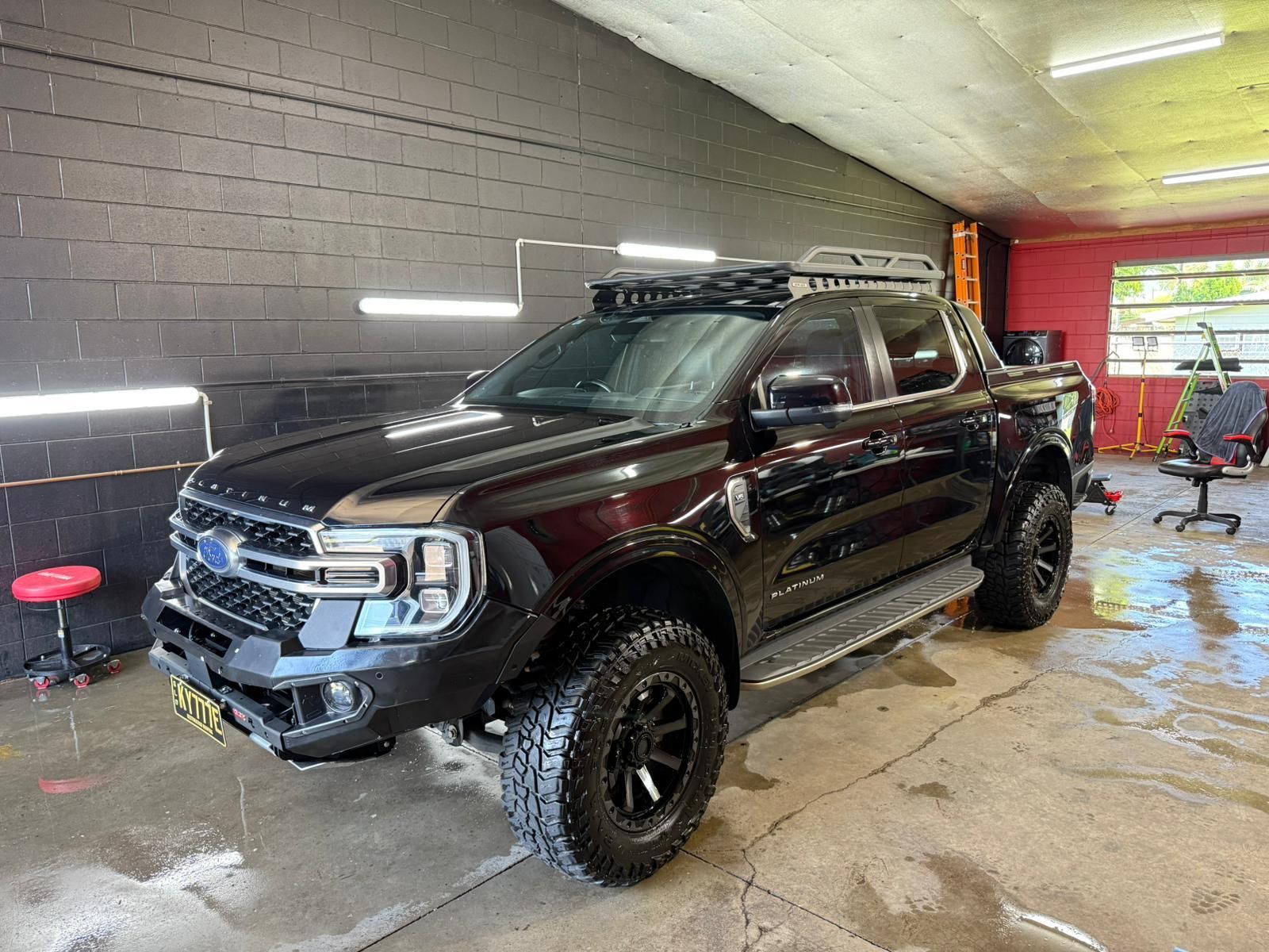 Black Ford Ranger truck with off-road tires, roof rack, and custom bumper — Mobile Club Cars Cairns in Earlville, QLD