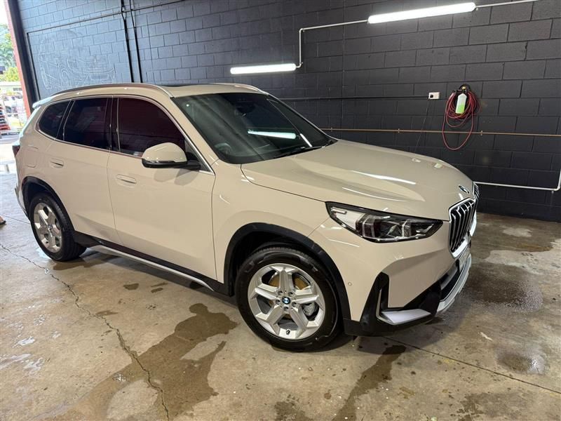 Cream-colored BMW SUV parked on a wet, concrete floor; a car wash setting — Mobile Club Cars Cairns in Earlville, QLD