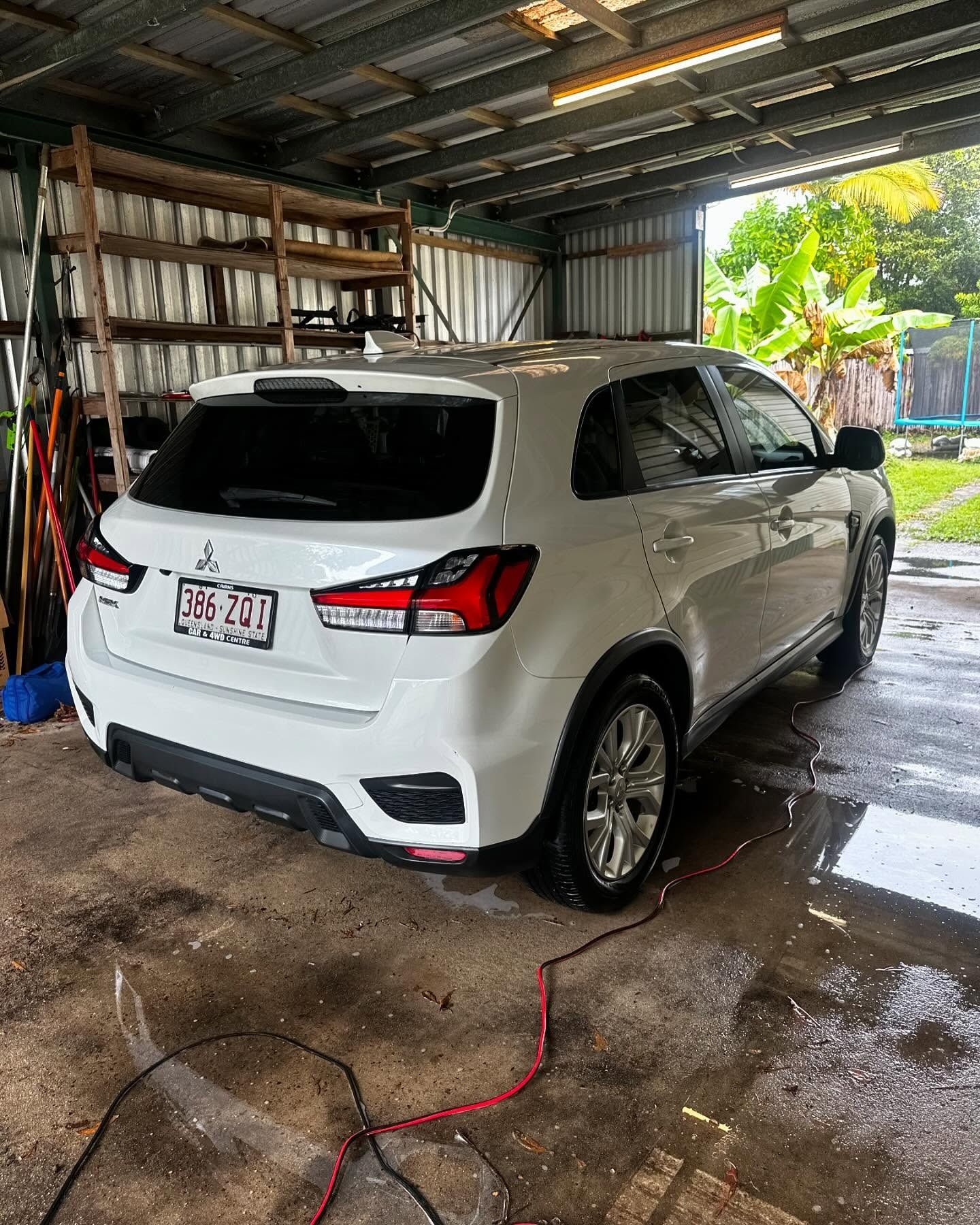 White Mitsubishi SUV parked in a garage with wet floor – Mobile Club Car Cleaning in Earlville, QLD
