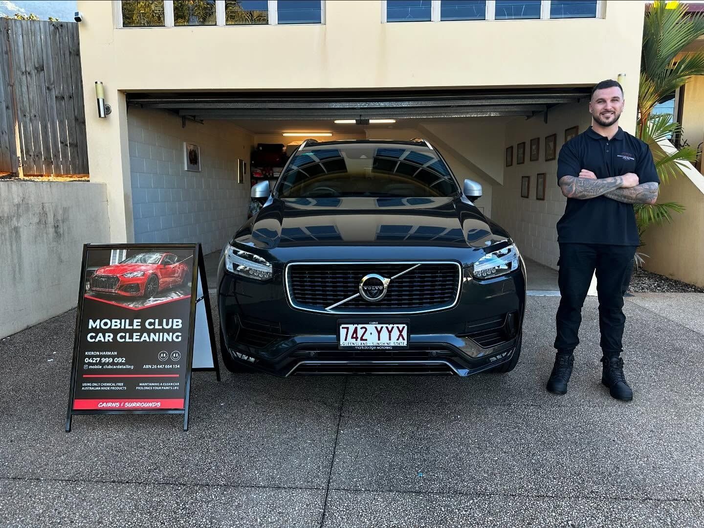 A Man Stands Beside a Black Volvo Suv in a Garage — Mobile Club Car Cleaning in Earlville, QLD