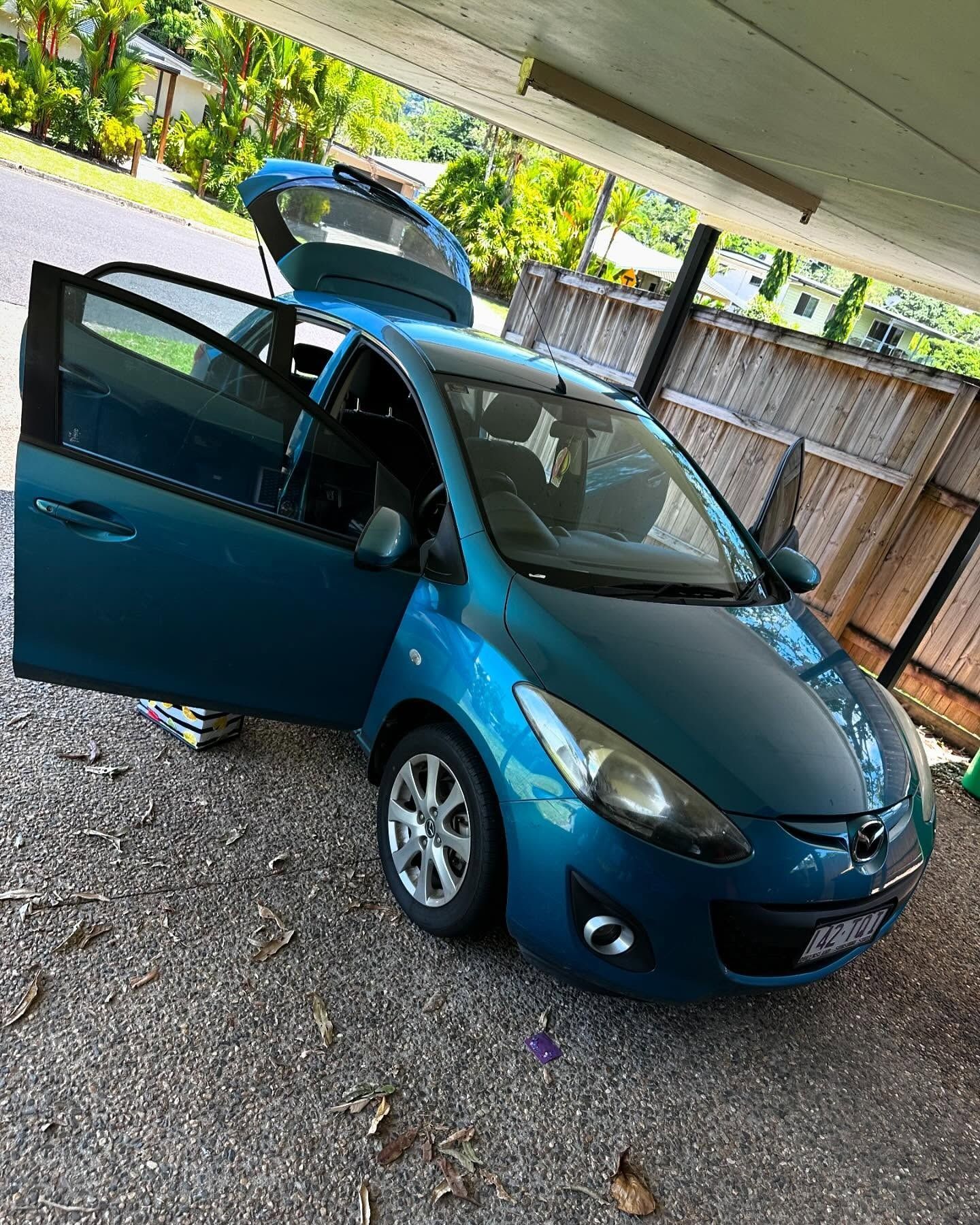 Blue Mazda 2 Parked With Doors Open on Gravel — Mobile Club Car Cleaning in Earlville, QLD