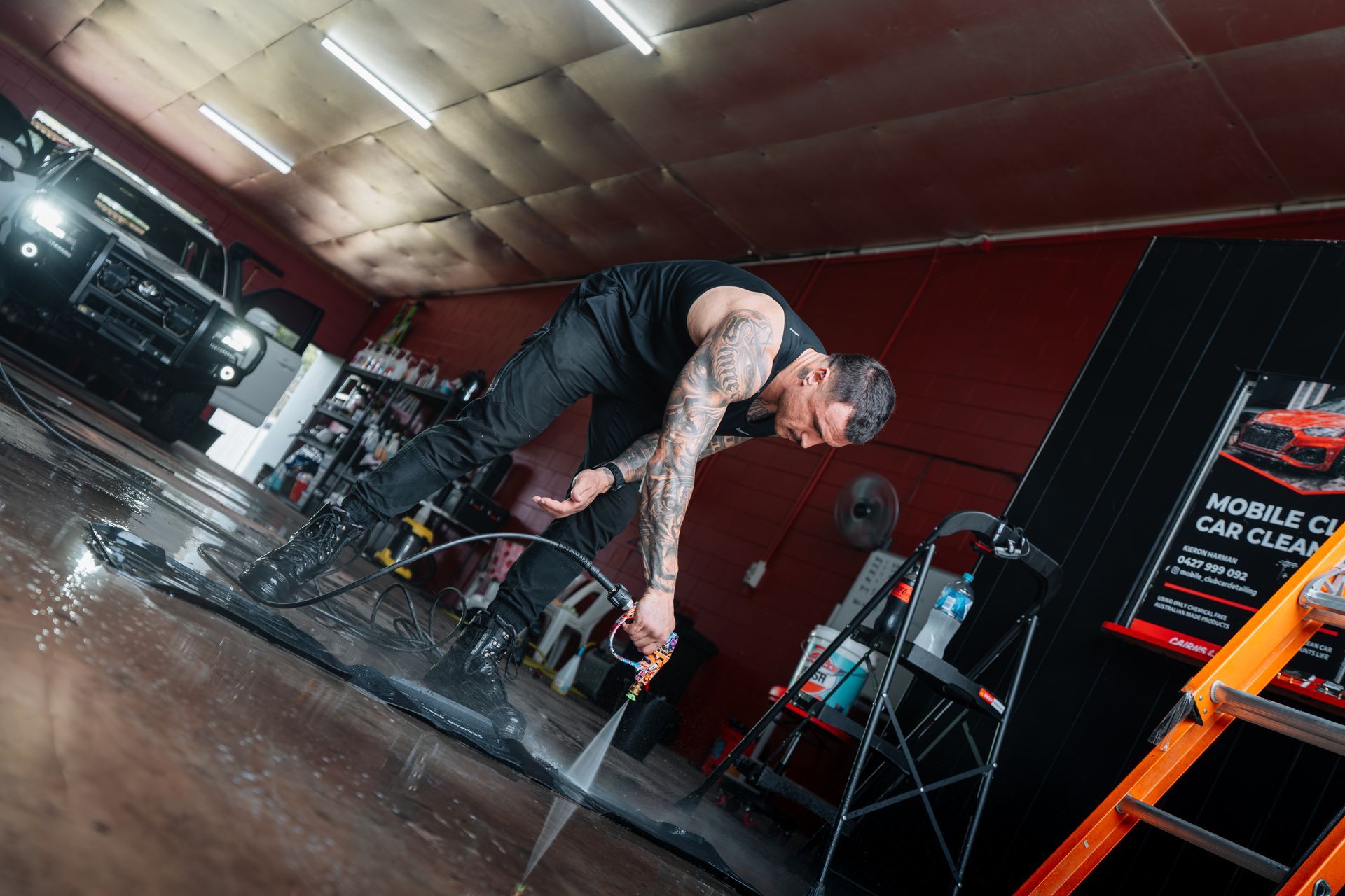 Man Washing a Car Inside a Garage; Water Spraying — Mobile Club Car Cleaning in Earlville, QLD