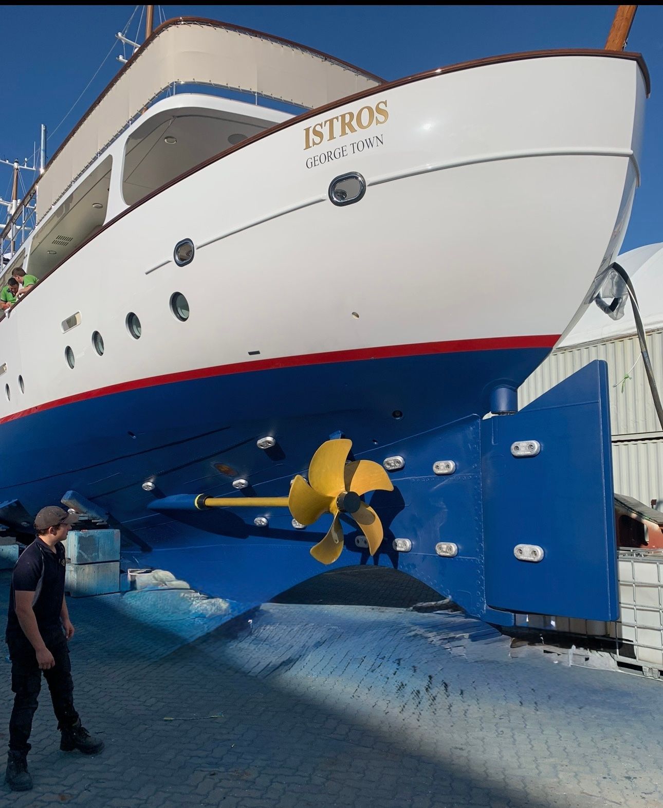 Boats on trailers lined up at a boat storage facility. White and blue hulls against a cloudy sky.