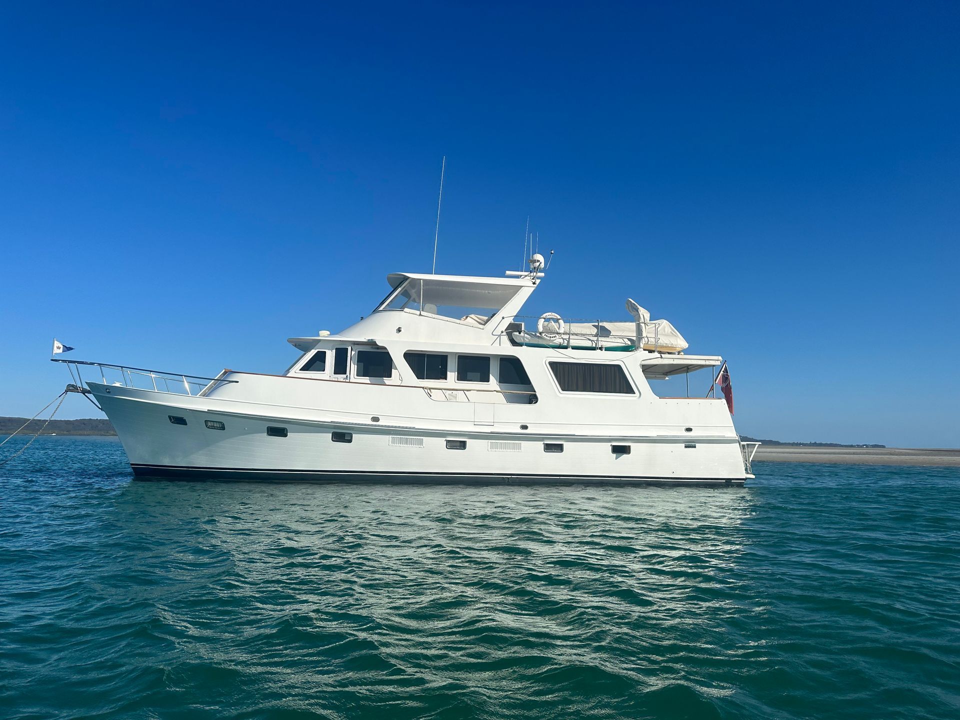 White motor yacht speeding across blue ocean.