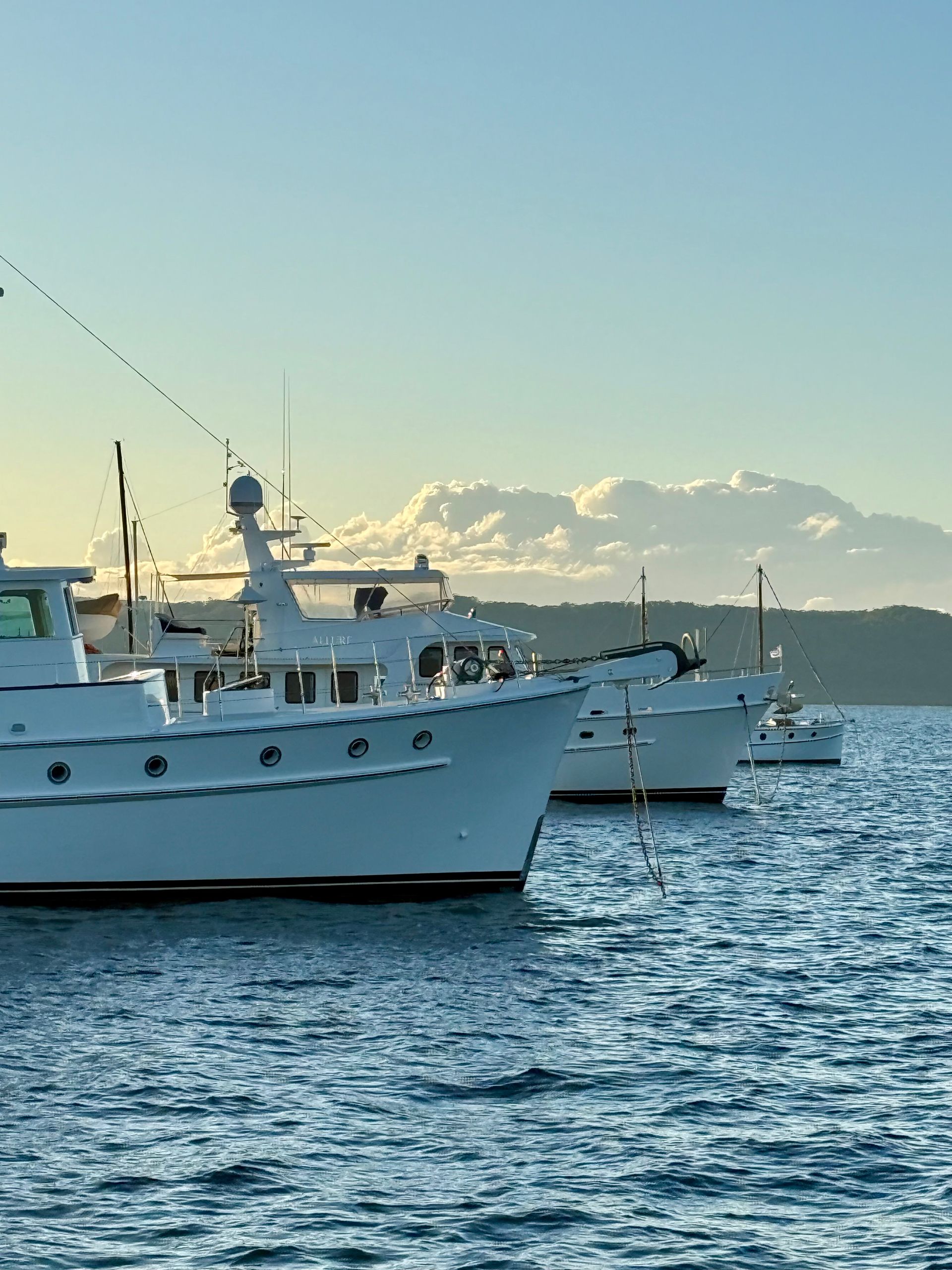 White motorboat speeding across blue water, creating white wake.