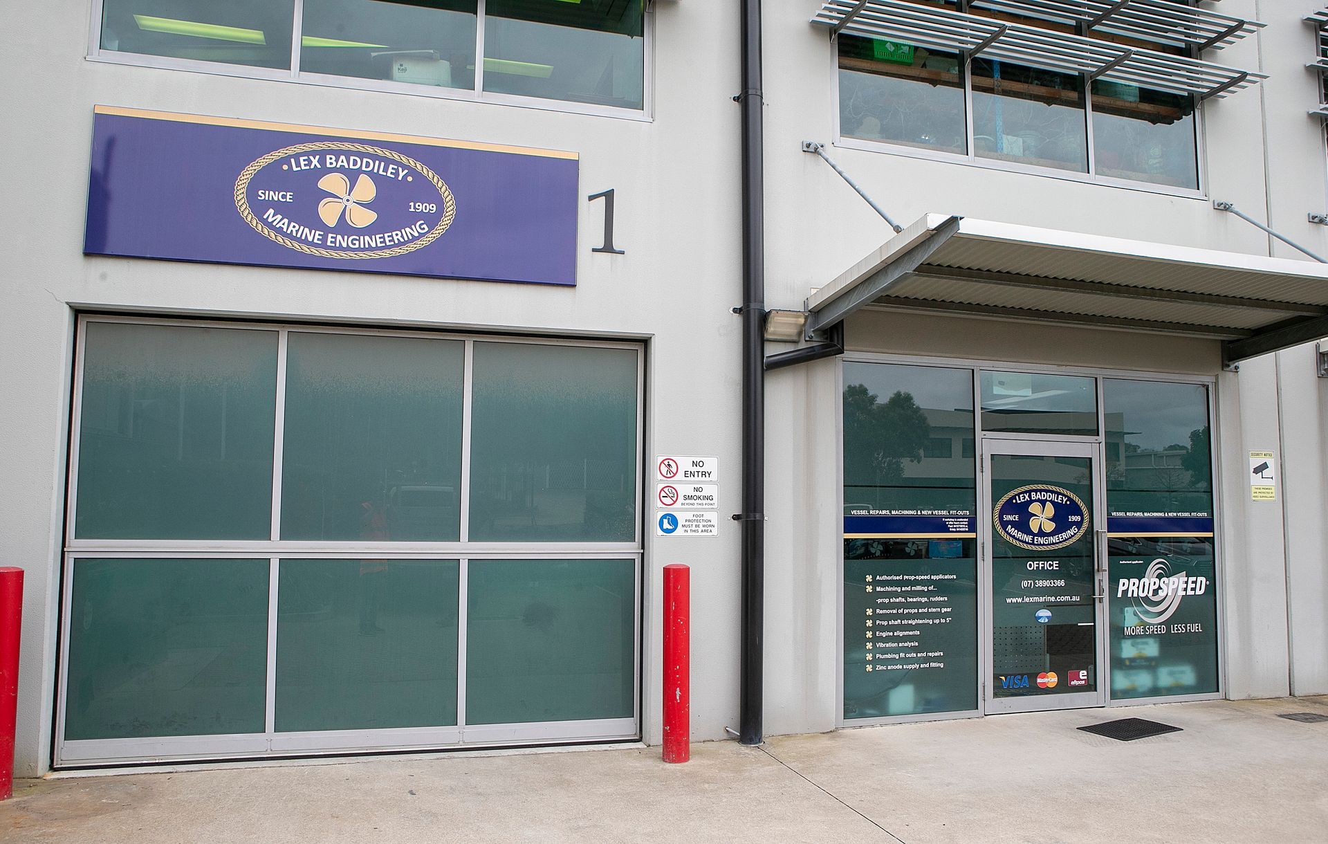 Building facade, "The Clinic" sign, glass door, garage door, awnings, and accessible parking sign.