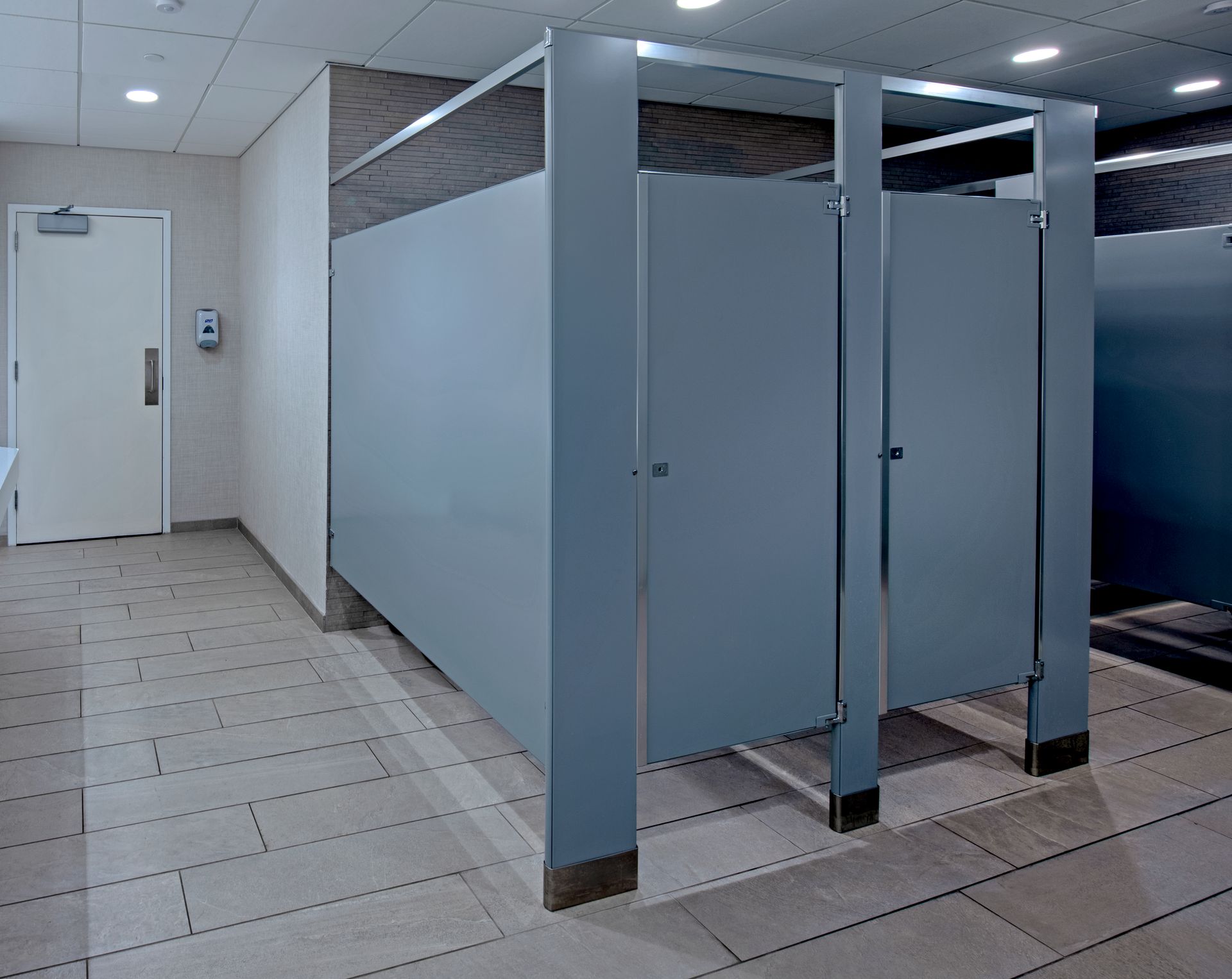 A hallway with a toilet cubicle and a door