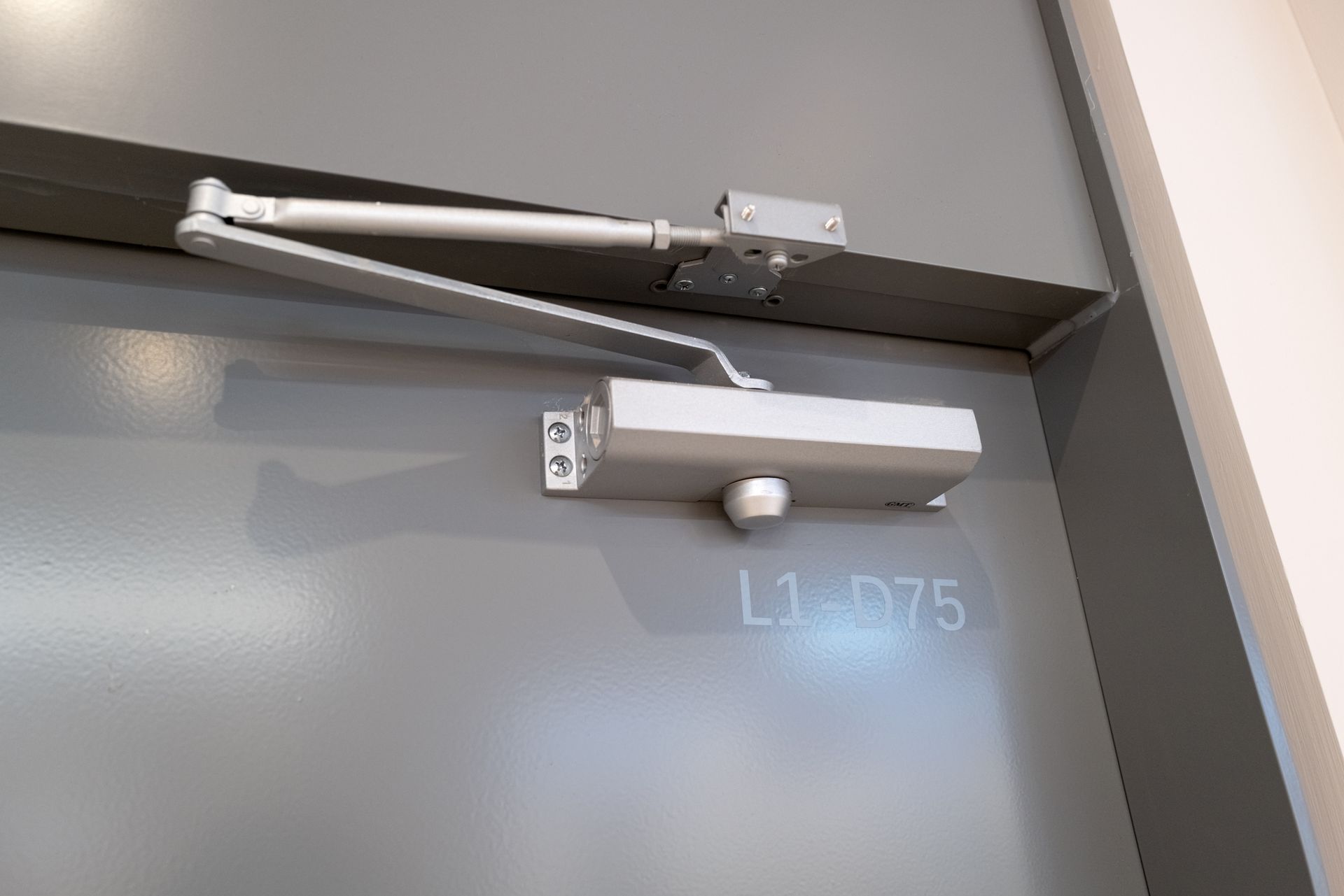 A close up of a door closer on a door.