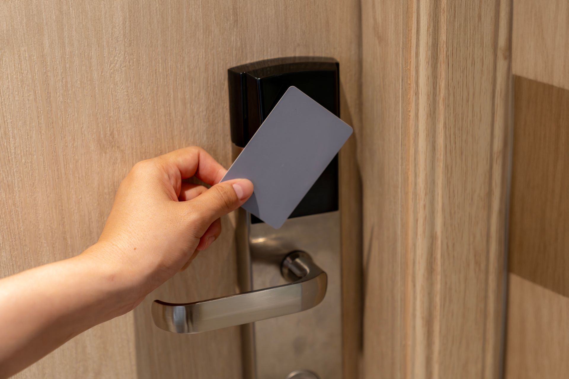 A person is inserting a credit card into a hotel door lock.