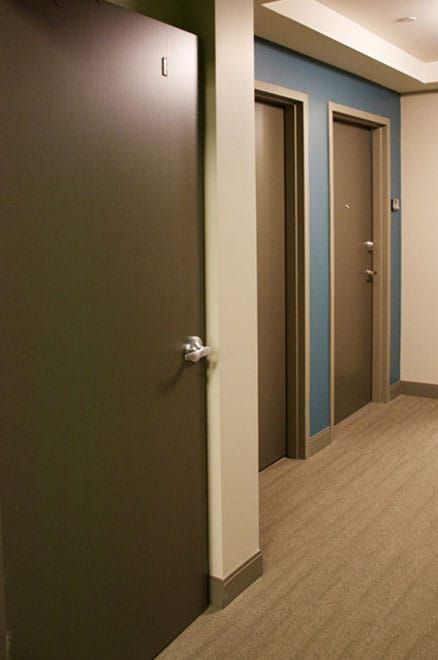 A hallway with a white door and a checkered floor.