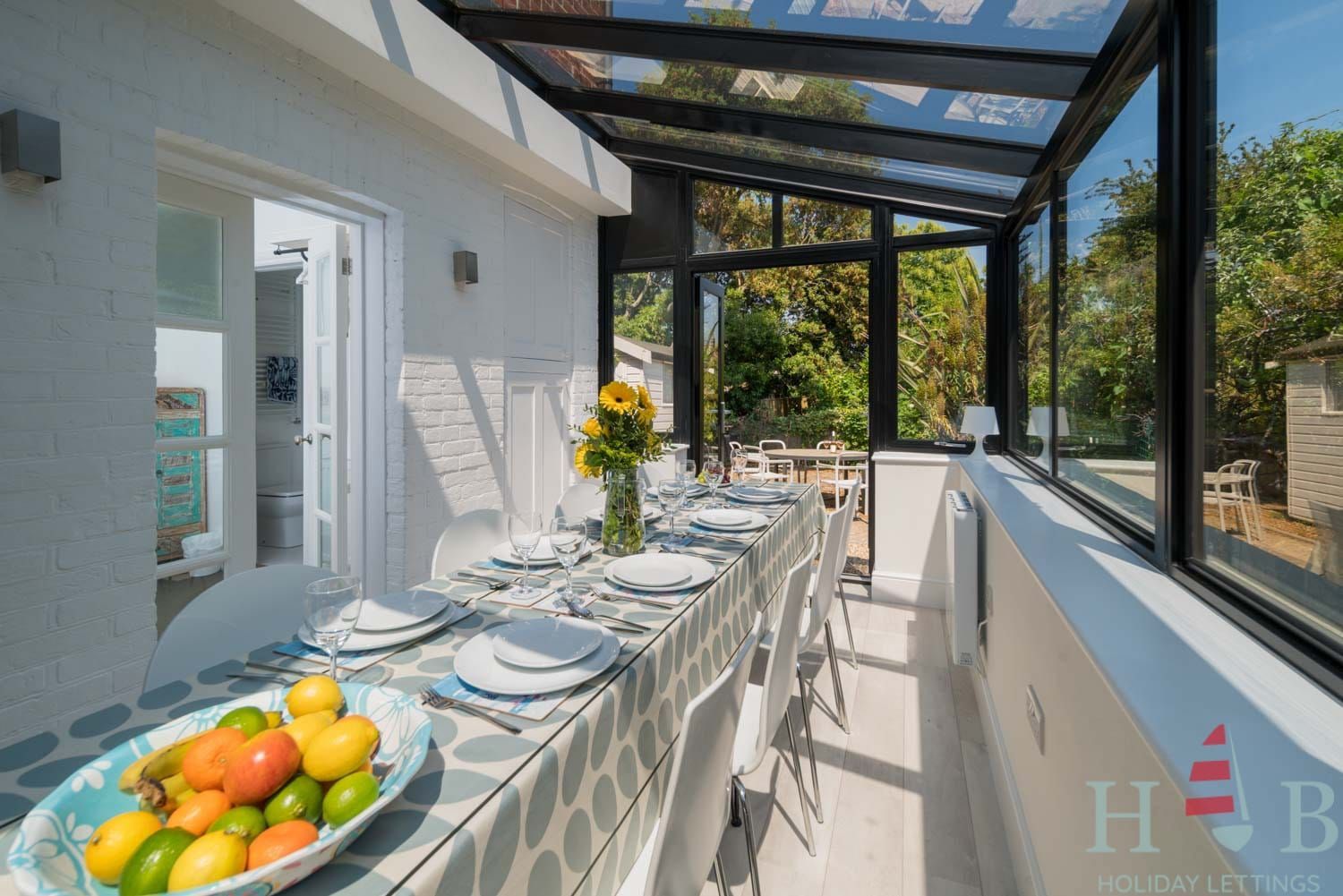 HB Holiday Lettings. A long dining table with a bowl of fruit on it.