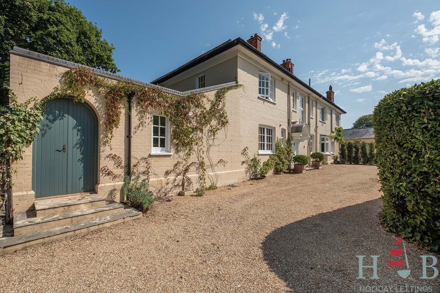 A large house with a gravel driveway leading to it