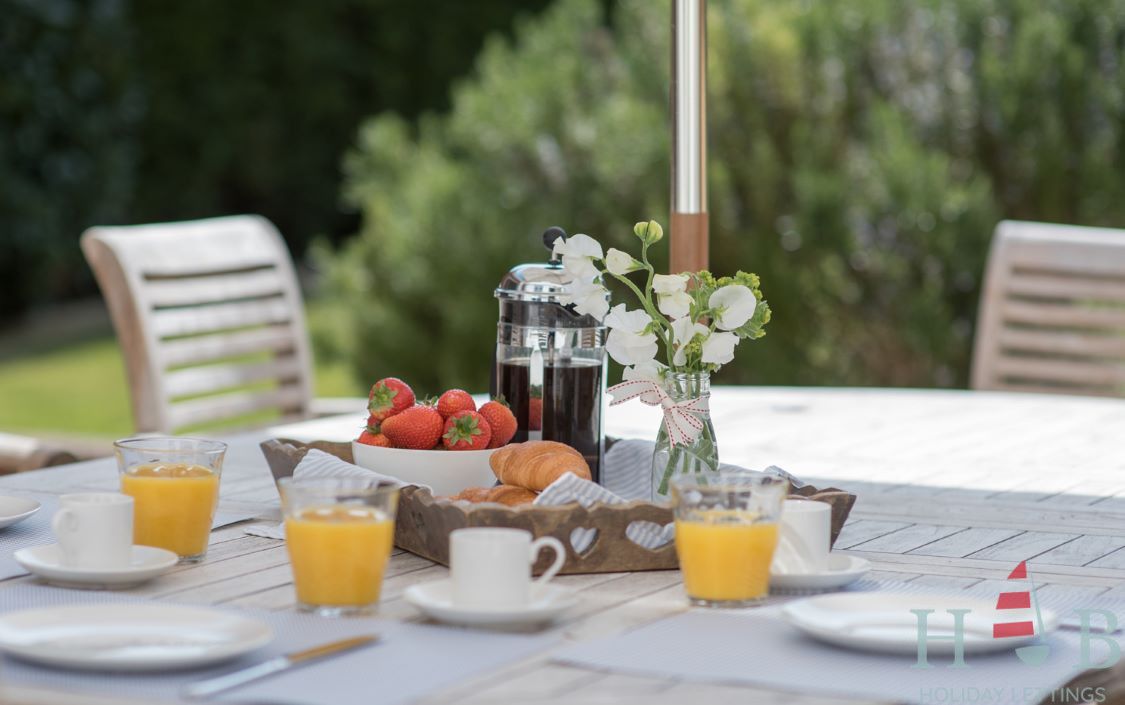 A table with a tray of strawberries and orange juice on it
