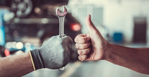 Worker with a wrench and a thumb up — Automotive Repair in Kinston, NC