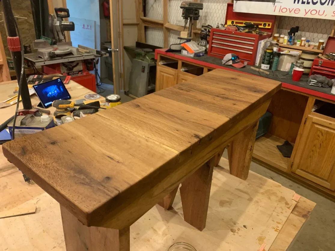 A wooden table is sitting on top of a wooden floor in a workshop.