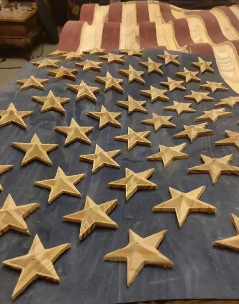 A large american flag with wooden stars on it