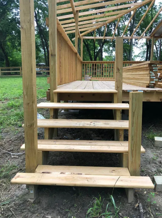 A wooden deck with stairs leading up to it