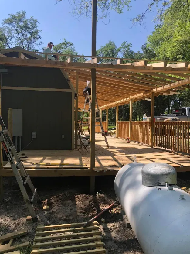 A propane tank is sitting next to a house under construction.