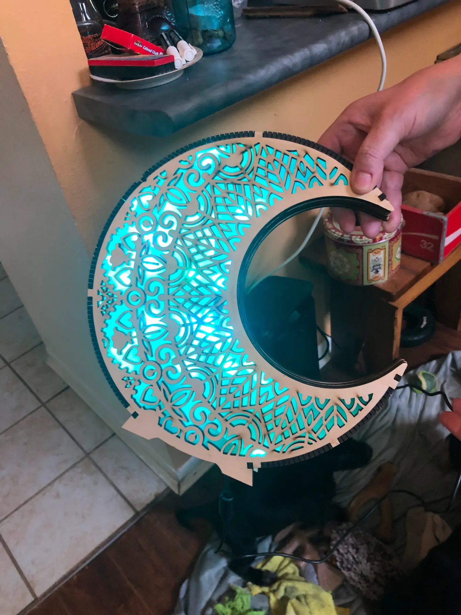 A person is holding a crescent moon shaped mirror in their hand.