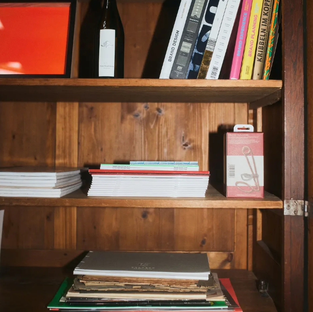 Holzregale mit Büchern, einer Flasche und einer Kiste.