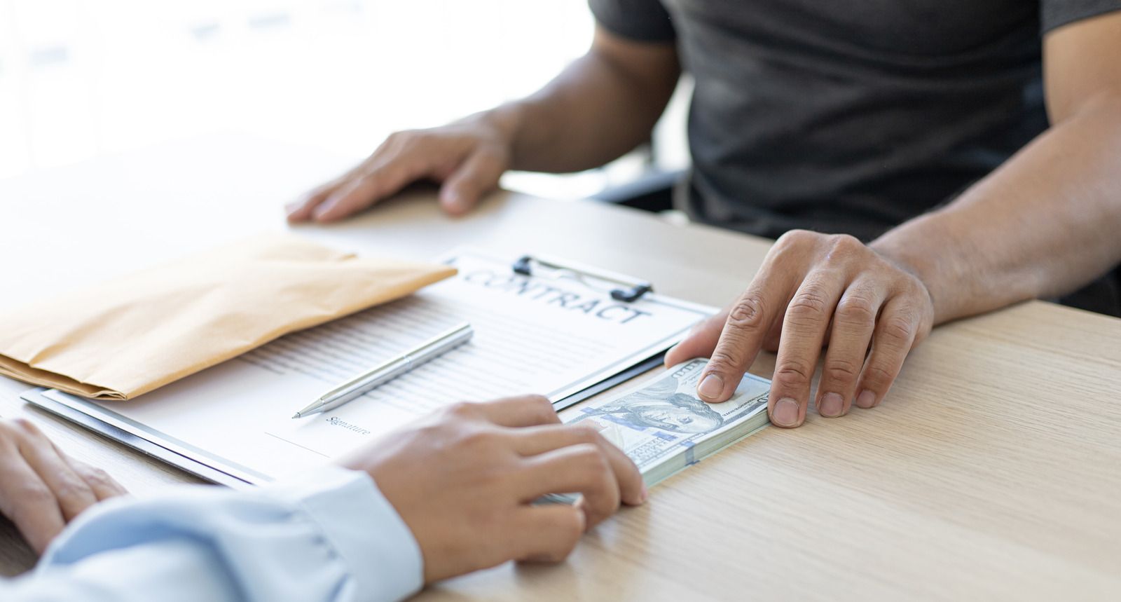 Two people are sitting at a table looking at a clipboard.