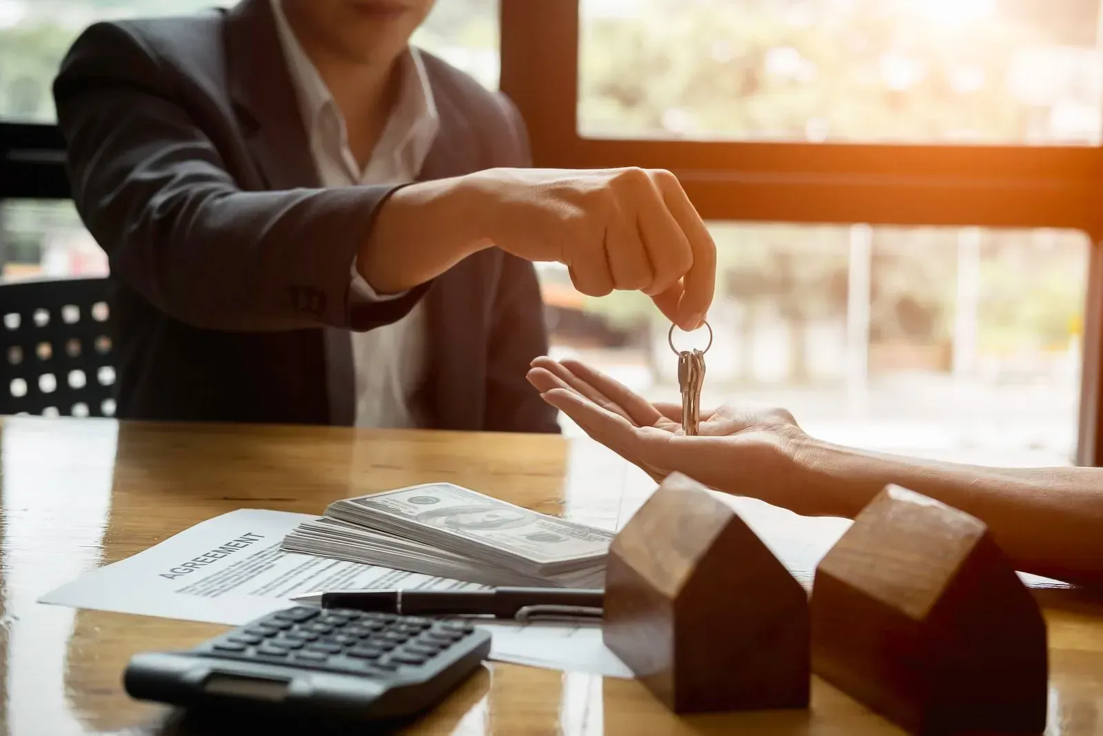 A man is handing a woman a set of keys.