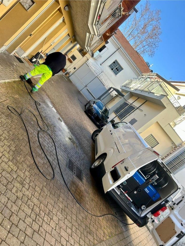 Un uomo sta lavando un furgone bianco in un parcheggio.